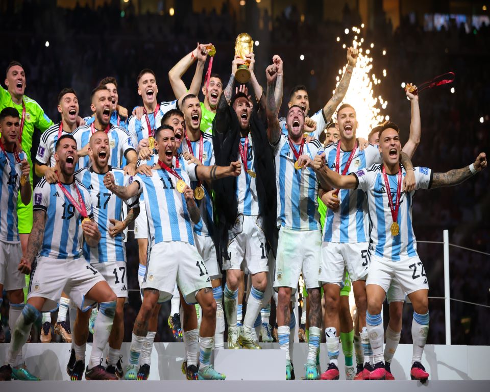 LUSAIL CITY, QATAR - DECEMBER 18: Lionel Messi of Argentina lifts trophy wearing a Bisht - traditional Arab robed as he lifts the world cup trophy surrounded by team mates uring the FIFA World Cup Qatar 2022 Final match between Argentina and France at Lusail Stadium on December 18, 2022 in Lusail City, Qatar. (Photo by Marc Atkins/Getty Images)