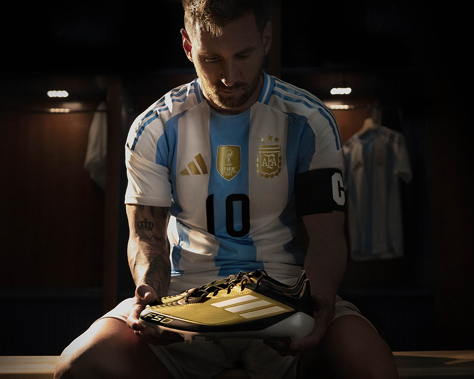 Argentine Forward, Lionel Messi, holding the adidas F50 Triunfo Dorado Football Boots.