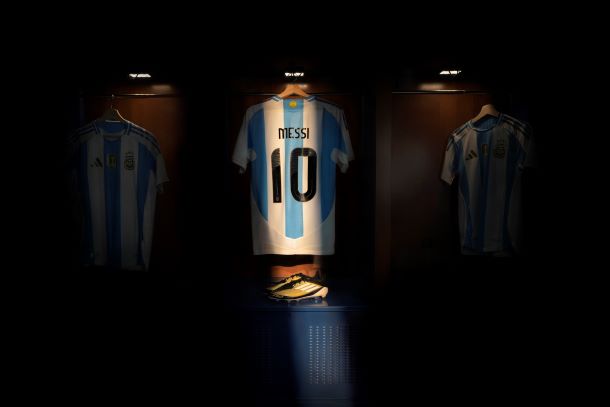 Messi's number 10 shirt illuminated with bright light next to the F50 Triunfo Dorado Boots sitting underneath.